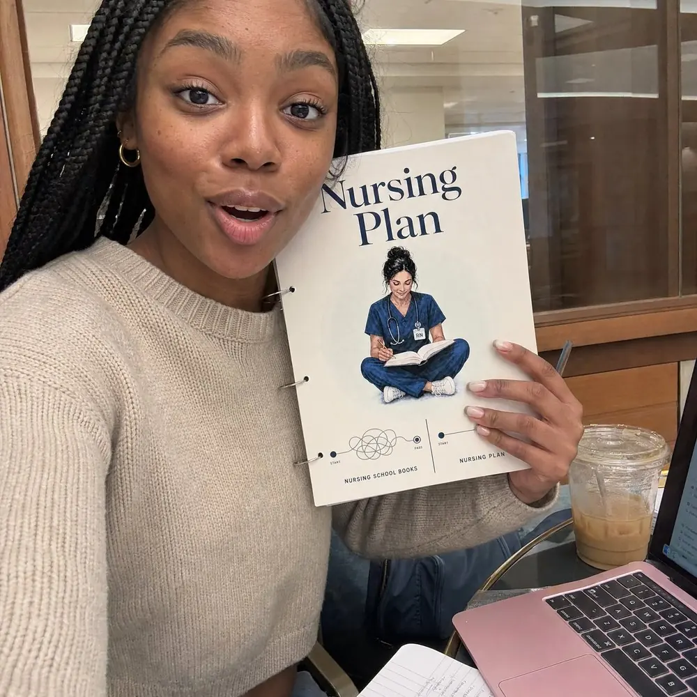 A nursing student holding her copy in the library